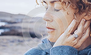 Portrait of a young woman, blonde with curly hair, with her eyes closed, sad and melancholy. Concept of winter, sadness,