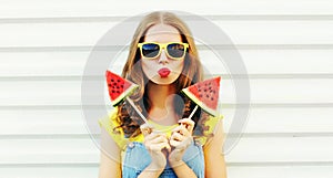 Portrait young woman blowing red lips with ice cream shaped watermelon over white