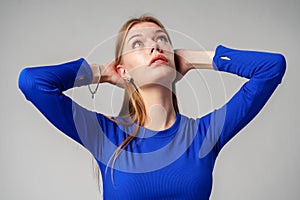 Portrait of Young Woman in Blue Top on gray background