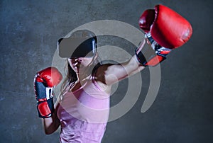 Portrait of young woman with boxing gloves playing video game using VR virtual reality goggles simulating boxer fighting 3D illusi