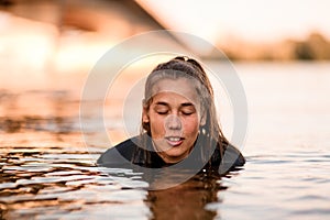 Portrait of young woman with closed eyes in deep water.