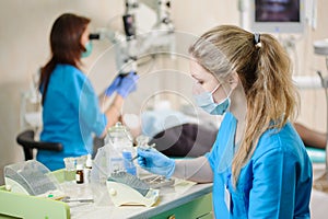 Portrait of young woman dentist assistant holding dental tool