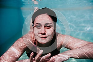 Portrait of young woman diving underwater in a pool. summer and fun lifestyle