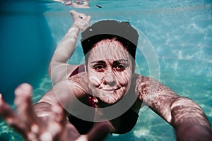 Portrait of young woman diving underwater in a pool. summer and fun lifestyle