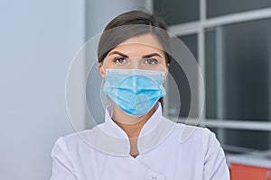 Portrait of young woman doctor nurse in protective medical face mask