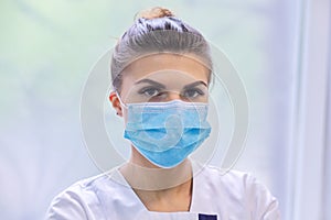 Portrait of young woman doctor nurse in protective medical face mask