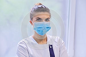 Portrait of young woman doctor nurse in protective medical face mask