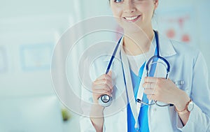 Portrait of young woman doctor with white coat standing in hospital