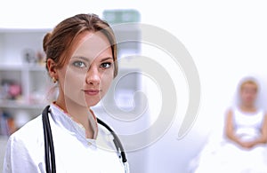 Portrait of young woman doctor with white coat standing in hospital