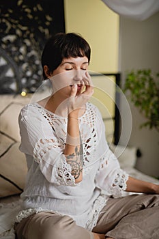Portrait of a young woman doing pranayama with her eyes closed.