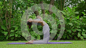 Portrait of a young woman doing yoga in the garden for a workout. Concept of lifestyle fitness and healthy. Asian women are practi