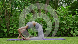 Portrait of a young woman doing yoga in the garden for a workout. Concept of lifestyle fitness and healthy. Asian women are practi