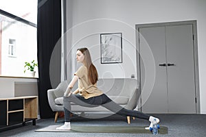 Portrait of young woman doing yoga at home on a mat