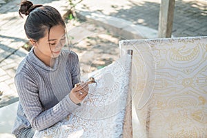 Portrait young woman drawing batik