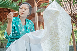 Portrait young woman drawing batik