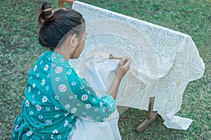 Portrait young woman drawing batik