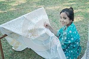 Portrait young woman drawing batik