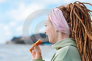 Portrait of a young woman with dreadlocks eating dried pastille. Concept of natural sugar free sweets