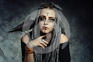 Portrait of a young woman with dreadlocks and with a raven