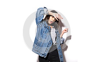 Portrait of a young woman dressed in jeans jacket standing isolated on a white background