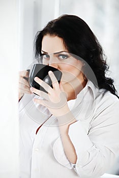 Portrait of young woman drinking a cup of coffee.