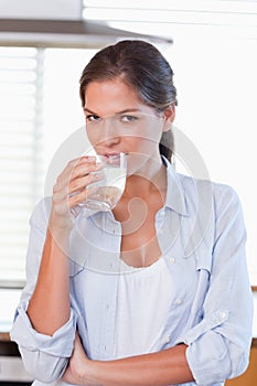 Portrait of a young woman drinking a glass of water