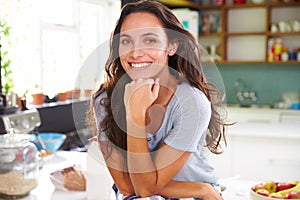 Portrait Of Young Woman Eating Breakfast In Kitchen