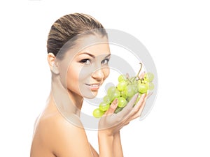 Portrait of a young woman eating fresh and tasty grapes