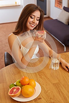 Portrait of Young Woman Eating Grapefruit. Healthy Lifestyle