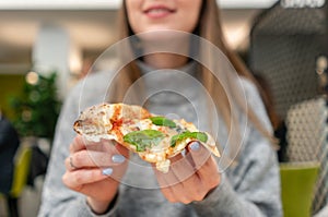 Portrait of young woman eating pizza. Neapolitan pizza from wood-burning stove. lunch in an Italian trattoria. Table