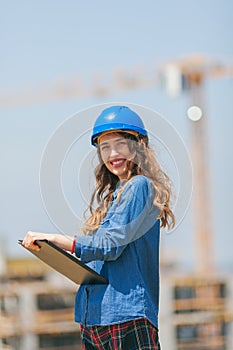 portrait of young woman engineer holding clipboard with documents