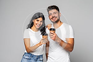 Portrait of a young woman enjoying a cup of coffee with her boyfriend in a studio