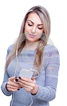 Portrait of young woman enjoying music using headphones, isolated over white