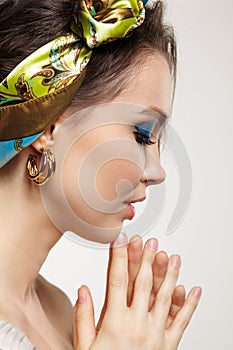 Portrait of young woman with eyes closed. Female posing in headscarf with hand near face