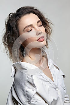 Portrait of young woman with eyes closed. Female posing in milky white corduroy shirt