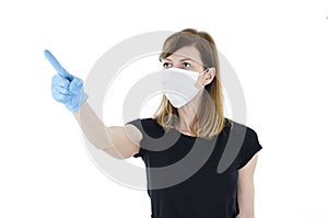 Portrait of young woman with face mask and blue gloves pointing finger up,