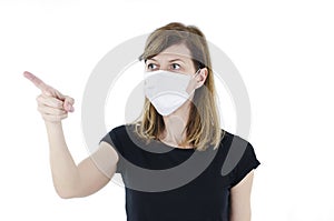 Portrait of young woman with face mask pointing finger up. 2019-nCov.