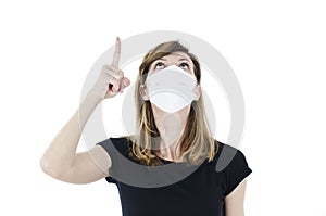 Portrait of young woman with face mask pointing finger up,
