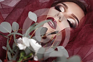 Portrait of young woman with fashionable makeup and eucalyptus b photo