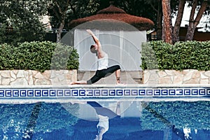 Portrait of young woman fitness, yoga, healthy body at the swimming pool. Freedom Concept. Outdoors. Yoga and mindfulness