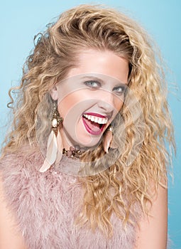 Portrait of a young woman with a flashy smile. Long wavy hair, makeup