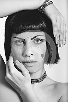 Portrait of young woman with freckles and heart-shaped stickers