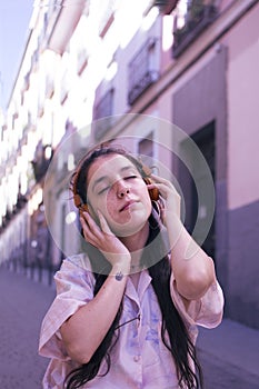 Young woman listening music on the street