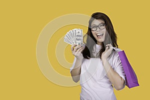 Portrait of a young woman gesturing on a yellow background.