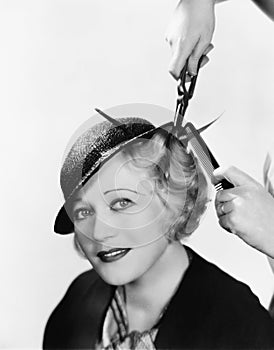 Portrait of a young woman getting her hair curled with an iron