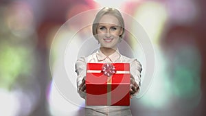 Portrait of young woman giving gift box.