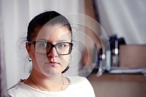 Portrait of young woman in glassess in bathroom