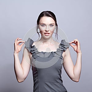 Portrait of young woman in gray dress on grÃÂµy background photo