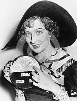 Portrait of a young woman in a hat holding a newly invented speedometer