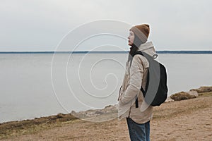 Portrait of young woman in a hat looking over the sea or the ocean, enjoying amazing nature, feeling of freedom